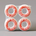 Four red and white skateboard wheels in packaging on a gray background