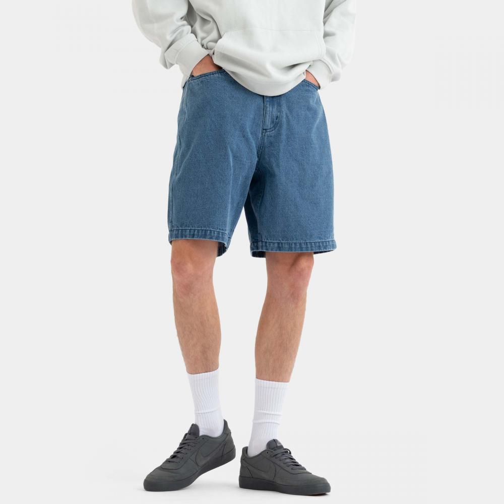 Person wearing blue denim shorts on a white background