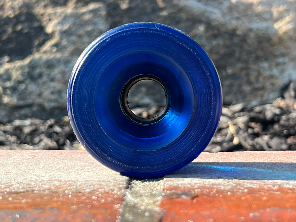 Blue cylindrical object on a textured surface with a blurred natural background